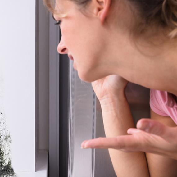 Woman Discovering Mold During Mold Assessment in Tampa, FL Room